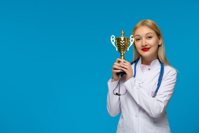 Premiazione sanitaria – Operatrice medica premiata con trofeo d’oro per l’eccellenza nel servizio di assistenza domiciliare integrata.